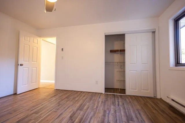 an empty room with closet and windows