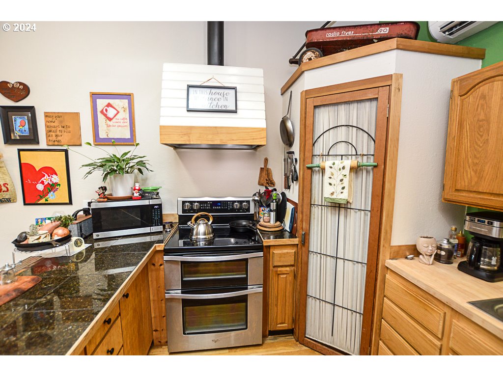 251 18th Street Springfield, OR 97477 - Photo 13 of 26 a kitchen with stainless steel appliances granite countertop a stove and a refrigerator