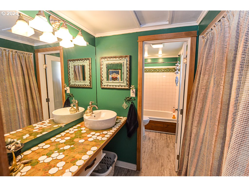 251 18th Street Springfield, OR 97477 - Photo 23 of 26 a bathroom with a sink a mirror and a shower