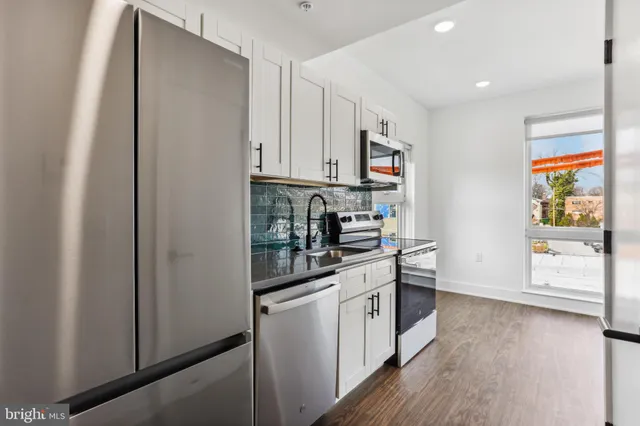 a kitchen with stainless steel appliances granite countertop a refrigerator and a stove top oven