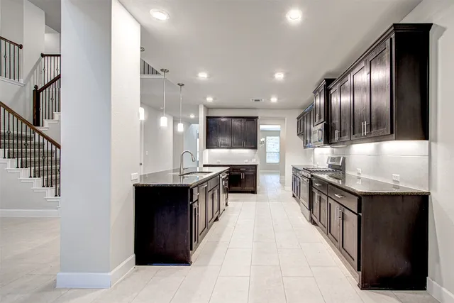 a large kitchen with stainless steel appliances a large counter top