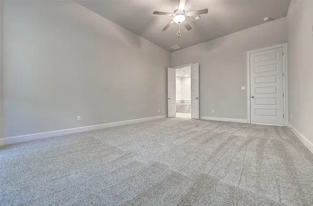 a view of an empty room with a chandelier fan