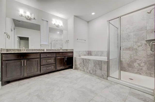 a spacious bathroom with a tub sink shower and mirror
