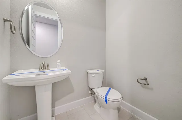 a bathroom with a toilet a sink and mirror