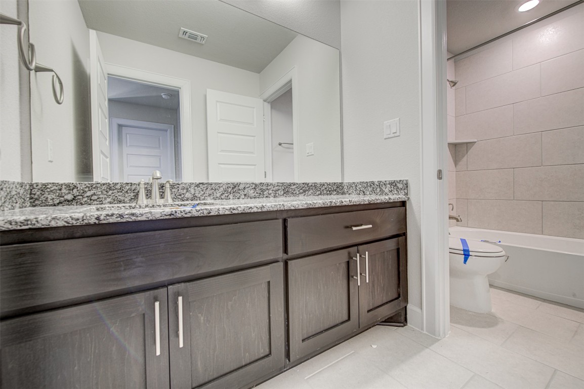 316 Buffalo Ridge Drive Manchaca, TX 78652 - Photo 27 of 37 a bathroom with a granite countertop sink a toilet and a mirror