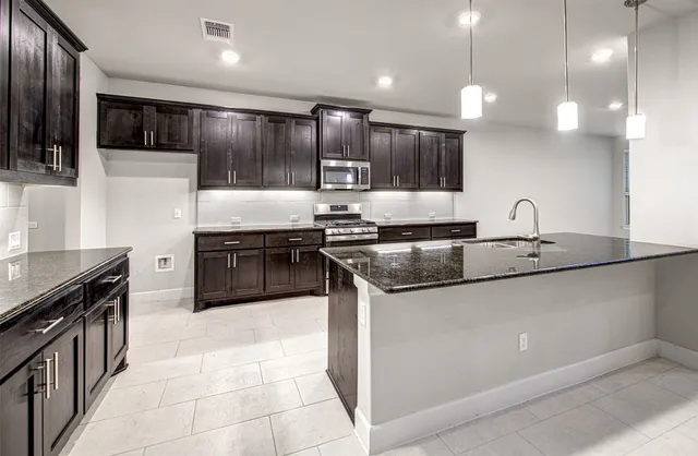 a kitchen with kitchen island granite countertop a sink and stove