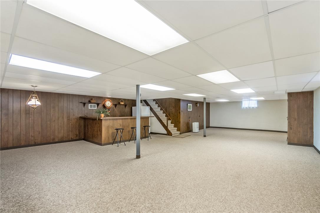 525 Wedgewood Road Bethlehem, PA 18017 - Photo 44 of 61 A spacious, finished basement features a built-in bar and carpeted flooring, perfect for recreation.