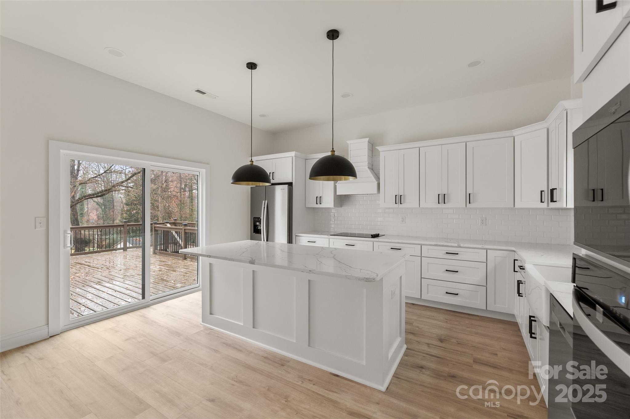 3021 Whitson Road Gastonia, NC 28054 - Photo 11 of 31 a kitchen with white cabinets and wooden floor