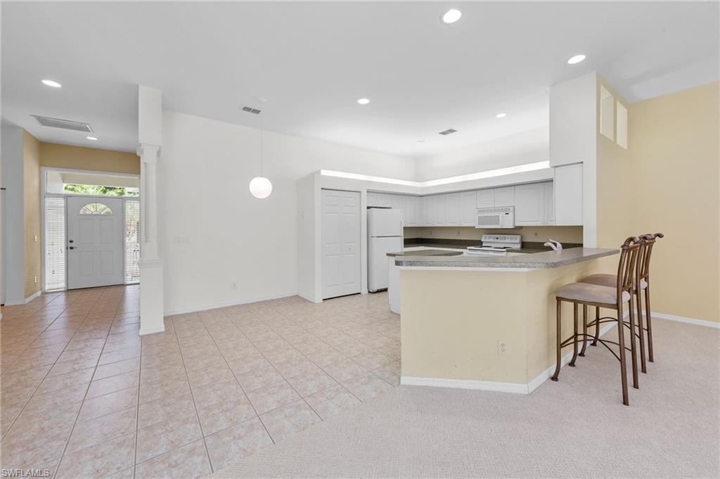23851 Amalfi Coast Road Estero, FL 34135 - Photo 12 of 49 a view of kitchen with cabinets and refrigerator