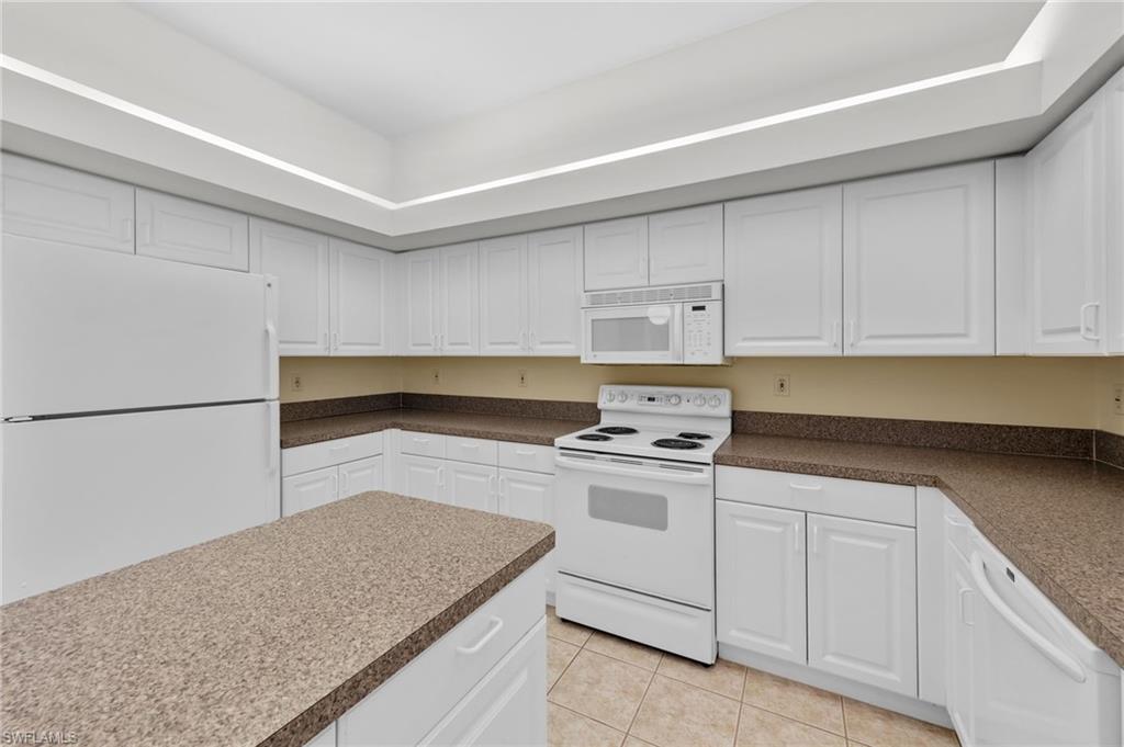 23851 Amalfi Coast Road Estero, FL 34135 - Photo 14 of 49 a kitchen with granite countertop white cabinets and white appliances