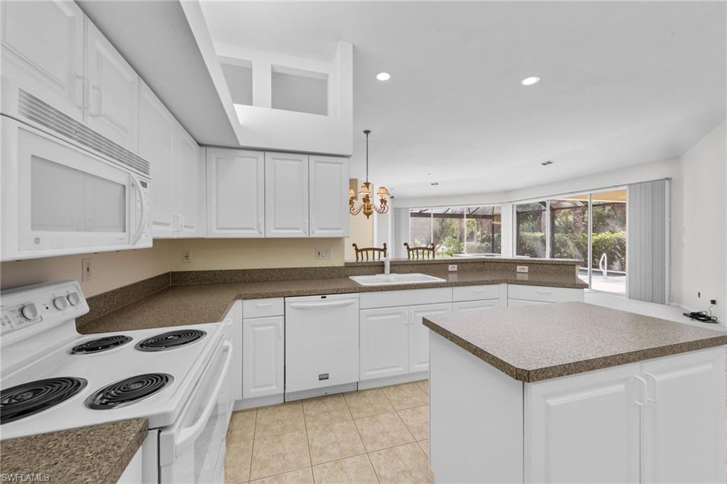 23851 Amalfi Coast Road Estero, FL 34135 - Photo 15 of 49 a kitchen with a sink a stove and cabinets