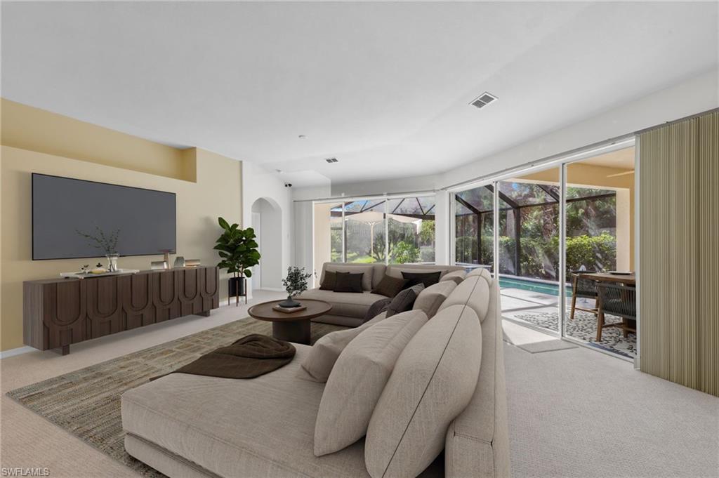 23851 Amalfi Coast Road Estero, FL 34135 - Photo 2 of 49 a living room with furniture a flat screen tv and floor to ceiling window