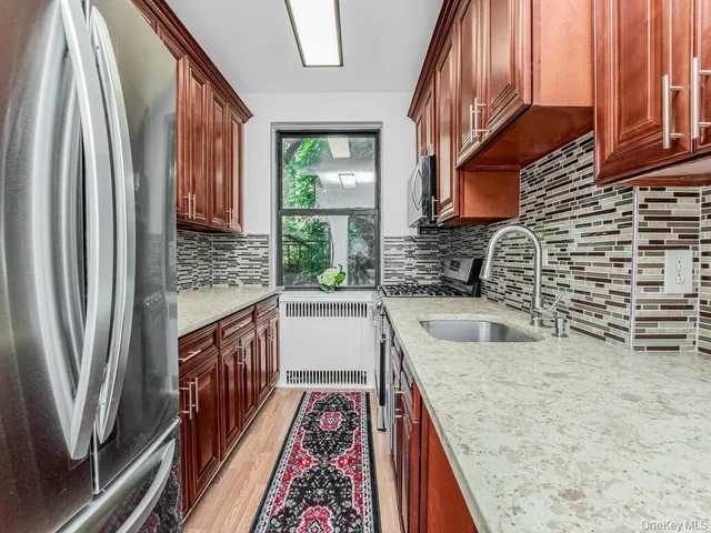 a kitchen with stainless steel appliances granite countertop a sink and a refrigerator