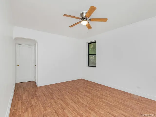 a view of a big room with wooden floor and a ceiling fan