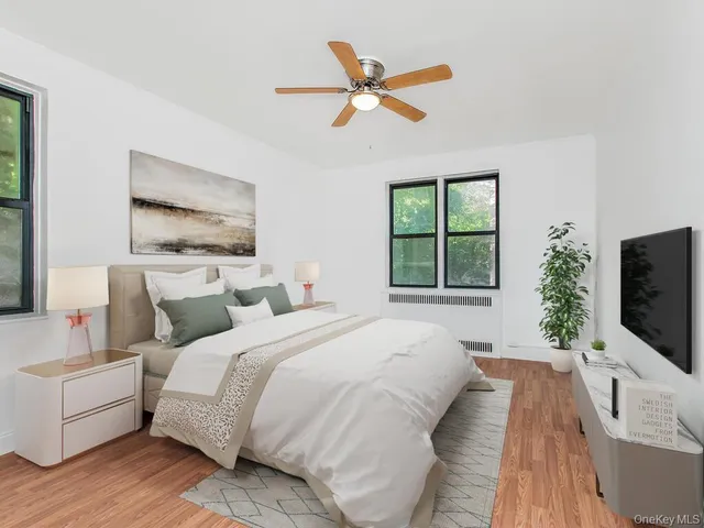 a spacious bedroom with a bed and a flat screen tv