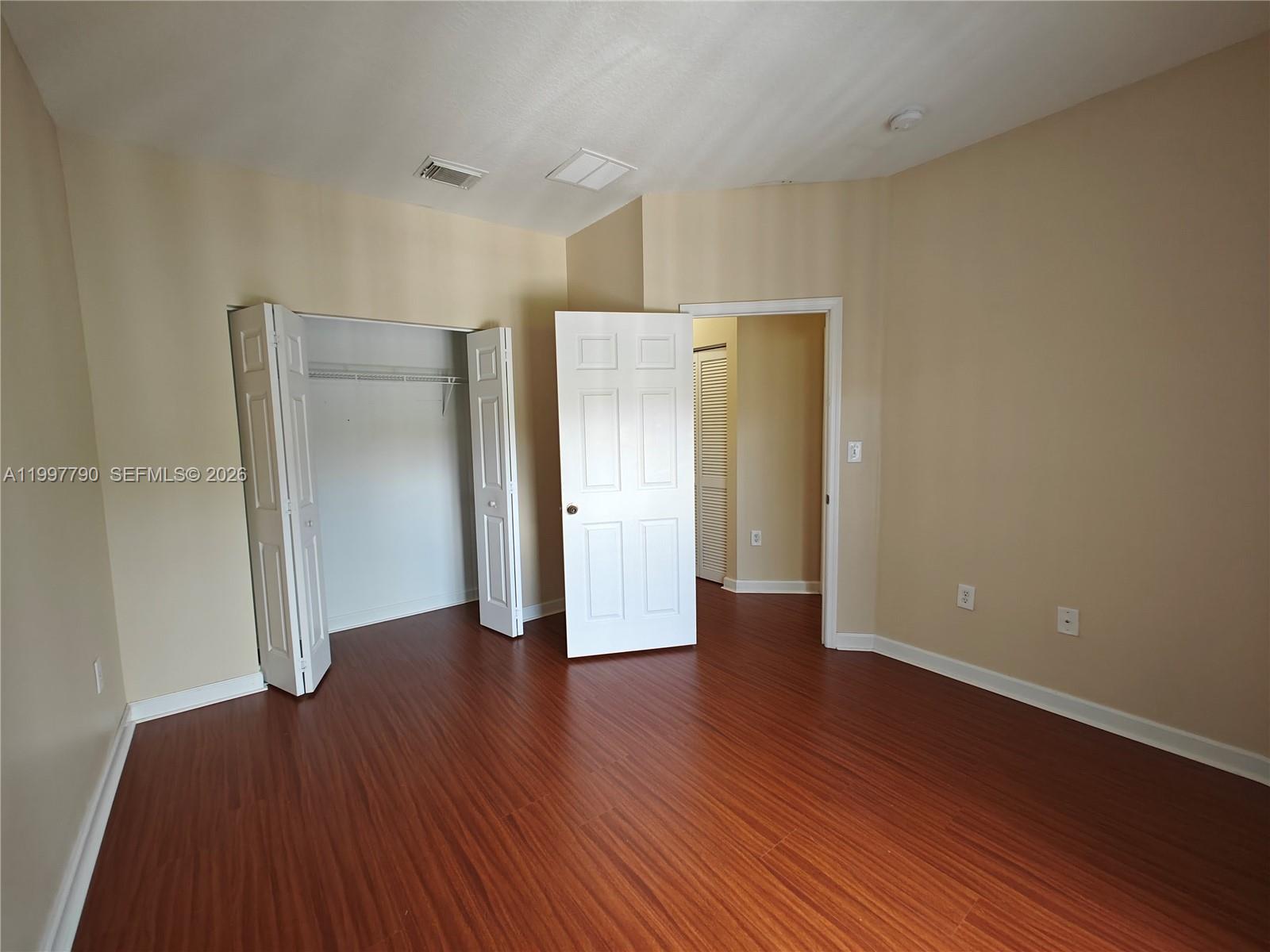 11252 Southwest 230th Terrace, Unit 11252 Miami, FL 33170 - Photo 20 of 28 a view of an empty room with wooden floor and closet