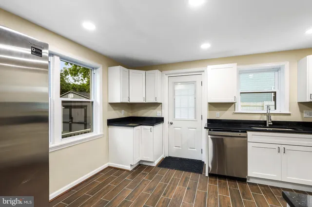 a kitchen with granite countertop a stove a sink and a refrigerator
