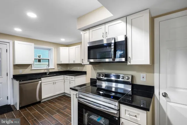 a kitchen with stainless steel appliances a stove a sink a microwave and cabinets