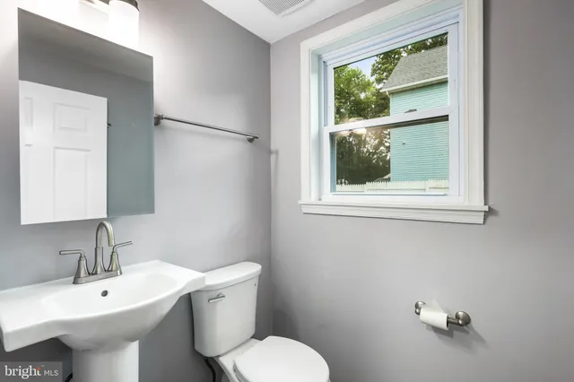 a bathroom with a sink toilet and a window