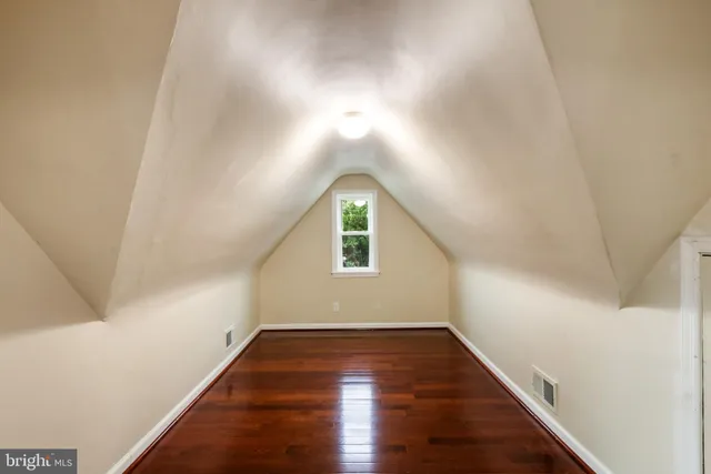 a view of a hallway with wooden floor and a window