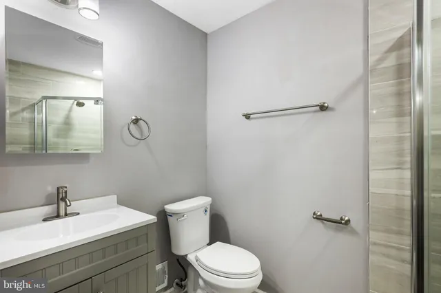 a bathroom with a sink mirror vanity and toilet