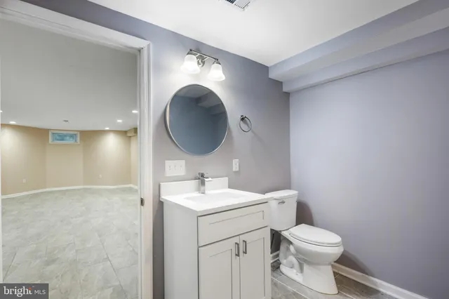 a bathroom with a toilet a sink and mirror