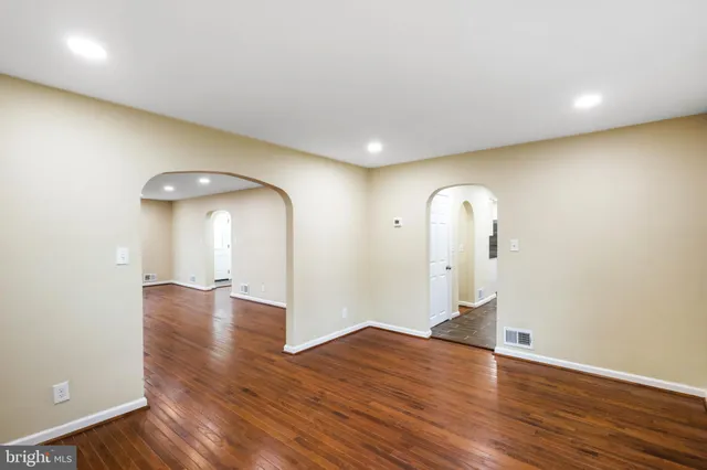 an empty room with wooden floor and mirror