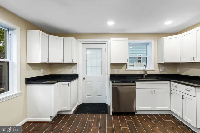 a kitchen with granite countertop white cabinets and white appliances