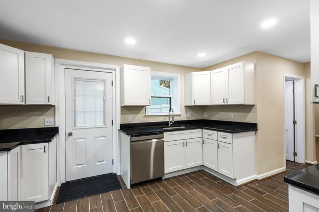 a kitchen with granite countertop a sink and cabinets