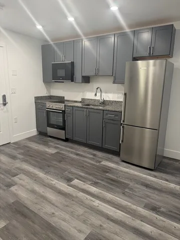 a kitchen with stainless steel appliances a refrigerator sink and microwave