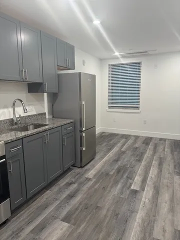 a kitchen with stainless steel appliances granite countertop a refrigerator and a sink
