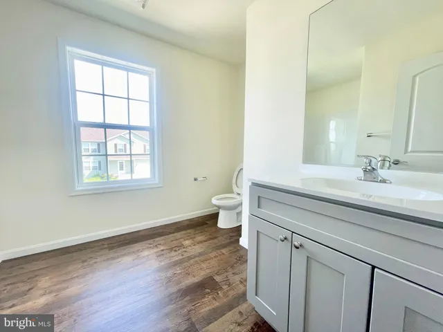 a bathroom with a sink a toilet and a window