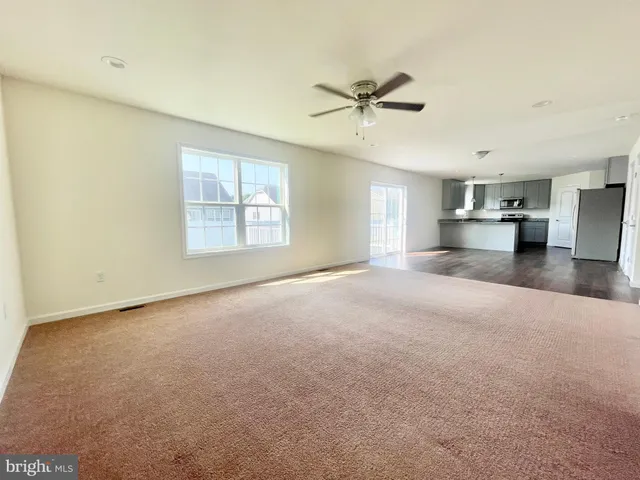 a view of a livingroom with a ceiling fan and window