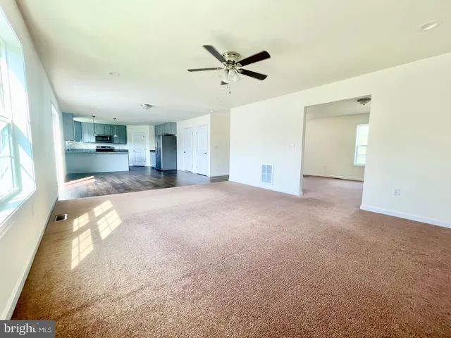 a view of a livingroom with a ceiling fan and window