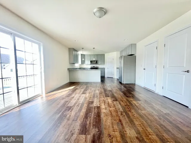 a view of a kitchen with wooden floor and electronic appliances