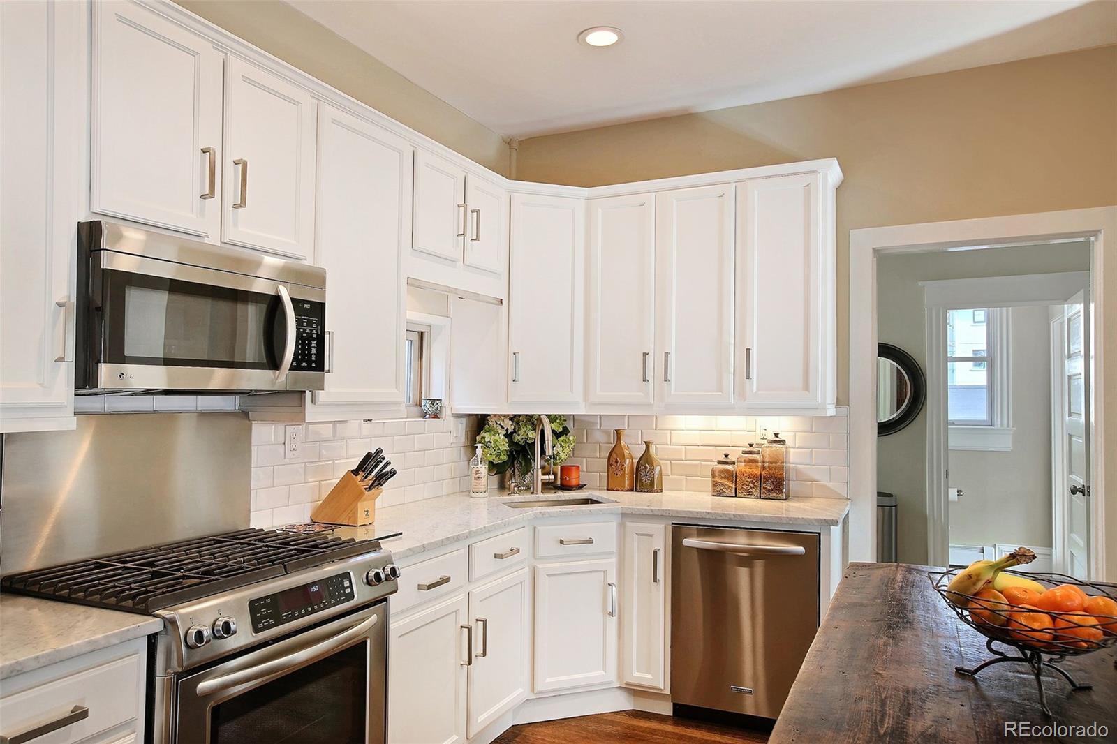 570 Gilpin Street Denver, CO 80218 - Photo 11 of 30 a kitchen with stainless steel appliances granite countertop a stove a sink and a microwave