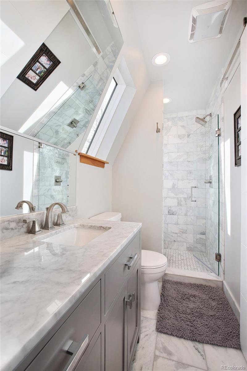 570 Gilpin Street Denver, CO 80218 - Photo 18 of 30 a bathroom with a granite countertop sink a toilet a mirror and shower