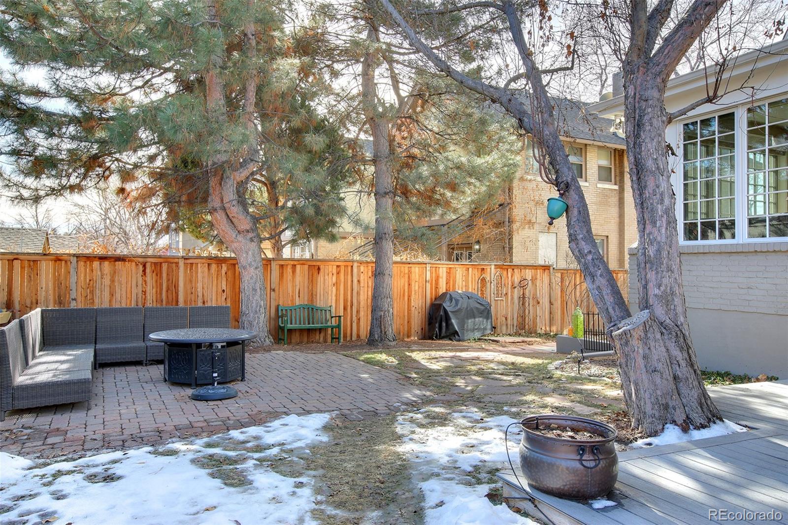 570 Gilpin Street Denver, CO 80218 - Photo 29 of 30 a view of a backyard with table and chairs potted plants and a large tree