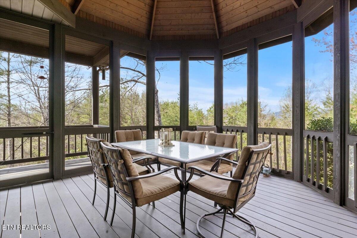 802 Stonegate Way Townsend, TN 37882 - Photo 3 of 44 a dining room with wooden floor glass walls and glass windows