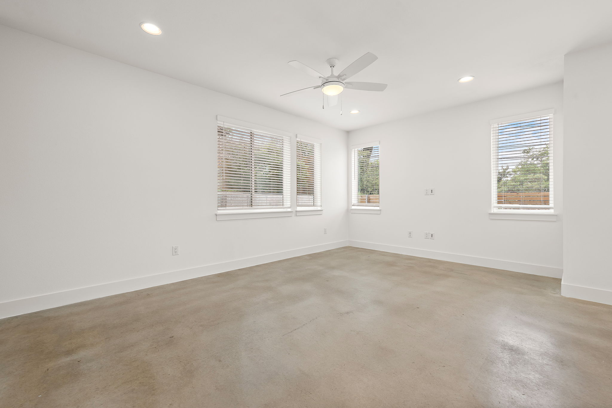 1206 Sarabeth Way Austin, TX 78721 - Photo 9 of 27 Empty room with ceiling fan, concrete flooring, baseboards, and recessed lighting