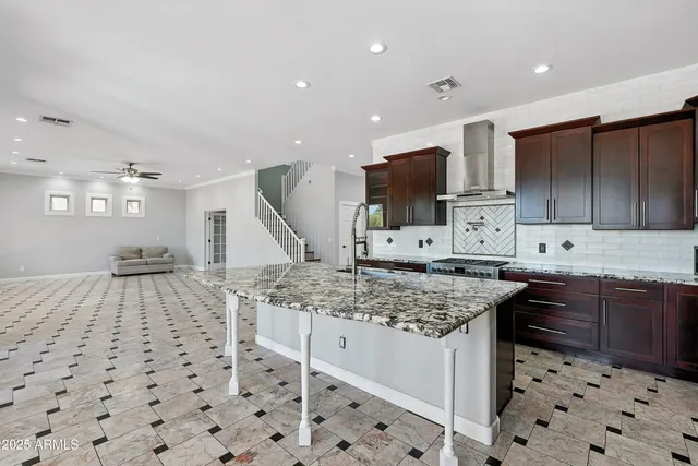 a kitchen with granite countertop a sink and a refrigerator