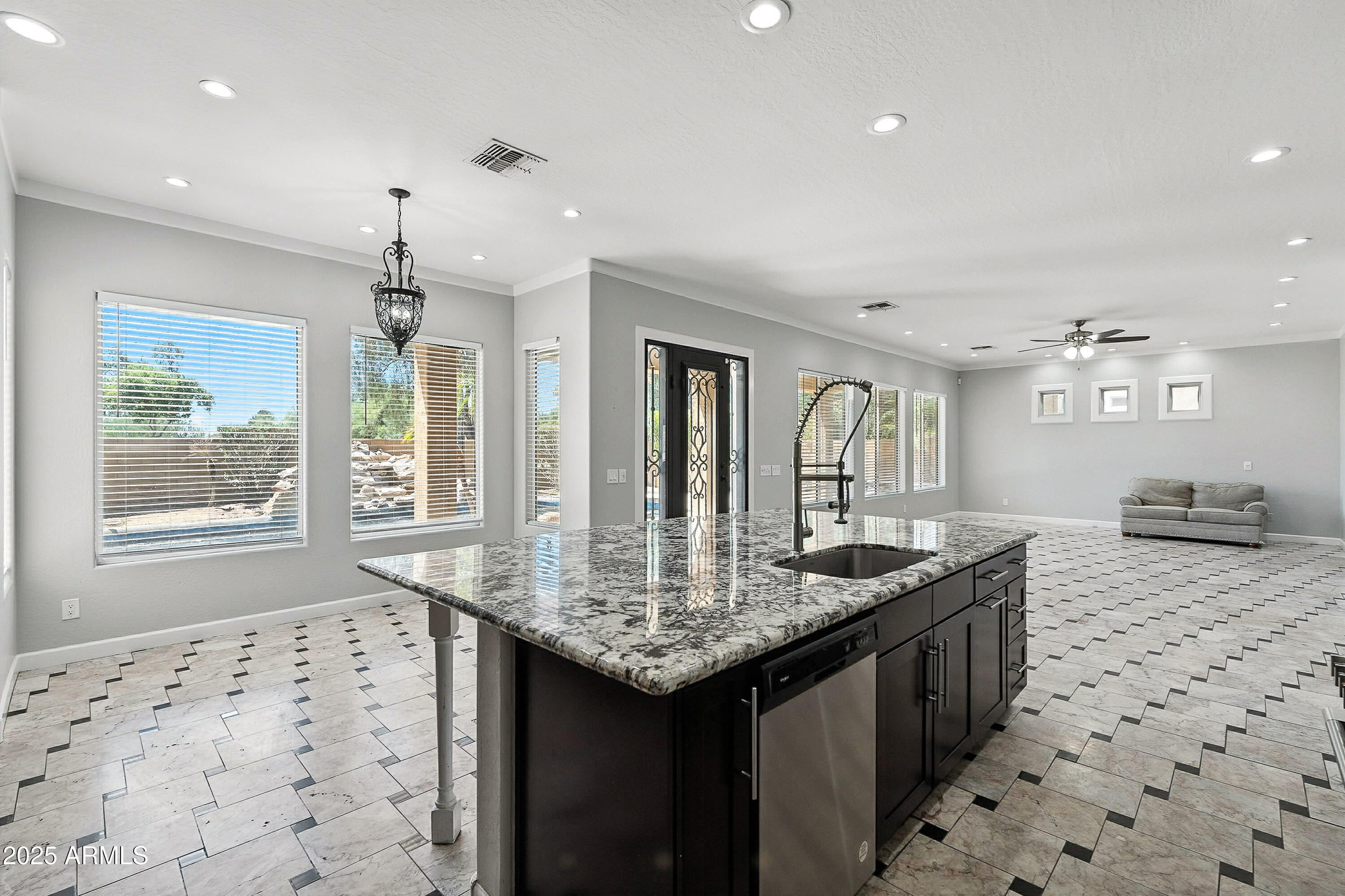 3042 South Seton Avenue Gilbert, AZ 85295 - Photo 9 of 71 a kitchen with granite countertop a sink and a refrigerator
