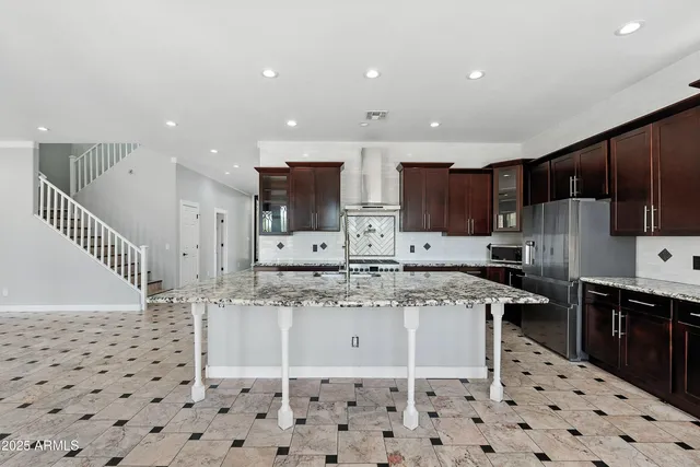 a kitchen with stainless steel appliances granite countertop a sink stove and refrigerator