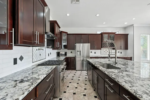 a kitchen with granite countertop a stove sink and cabinets