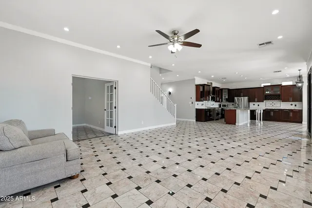 a living room with a large window and a chandelier