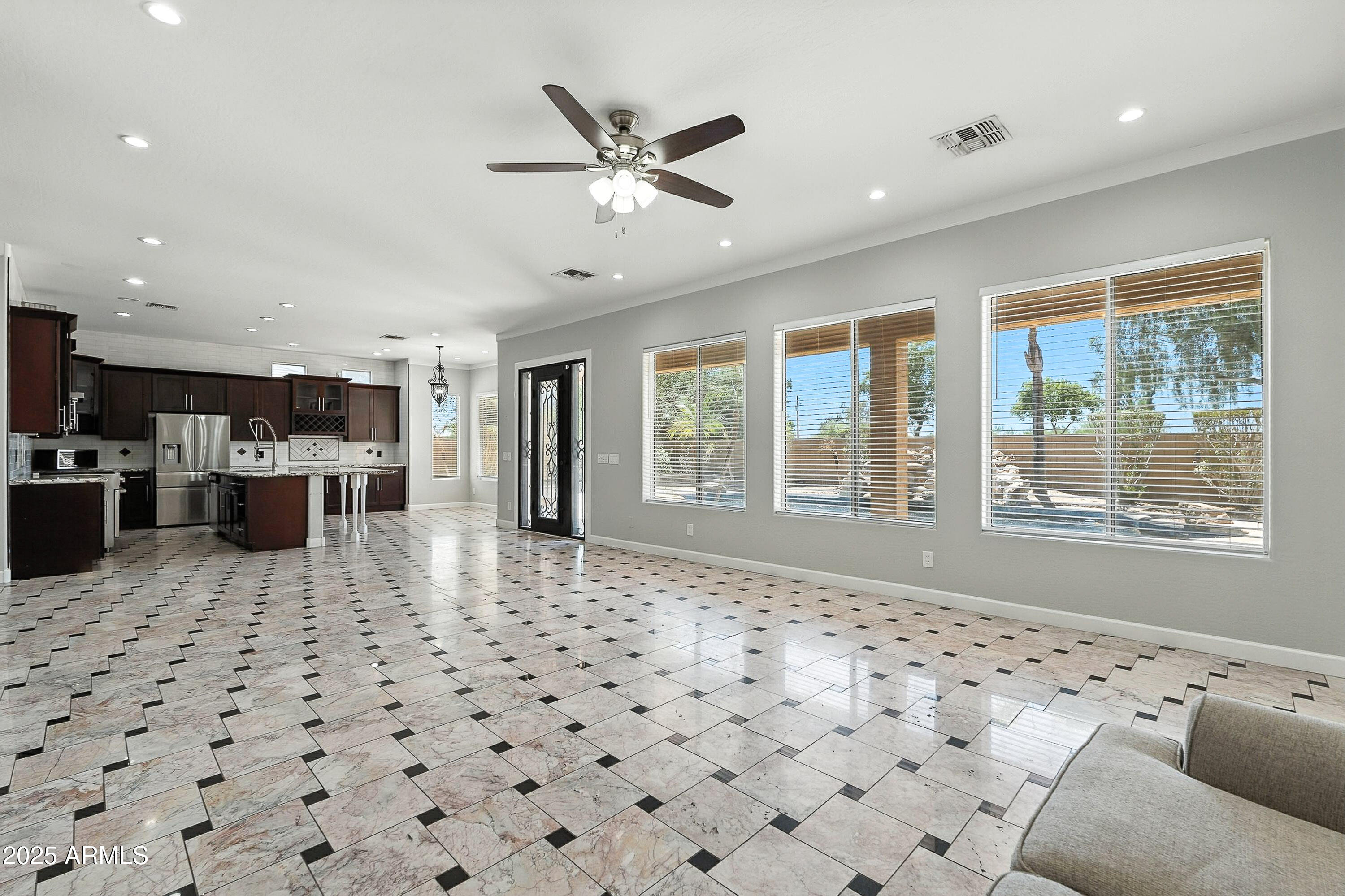 3042 South Seton Avenue Gilbert, AZ 85295 - Photo 15 of 71 a living room with a large window and a chandelier