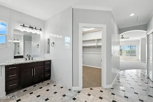 a view of an empty room with chandelier fan