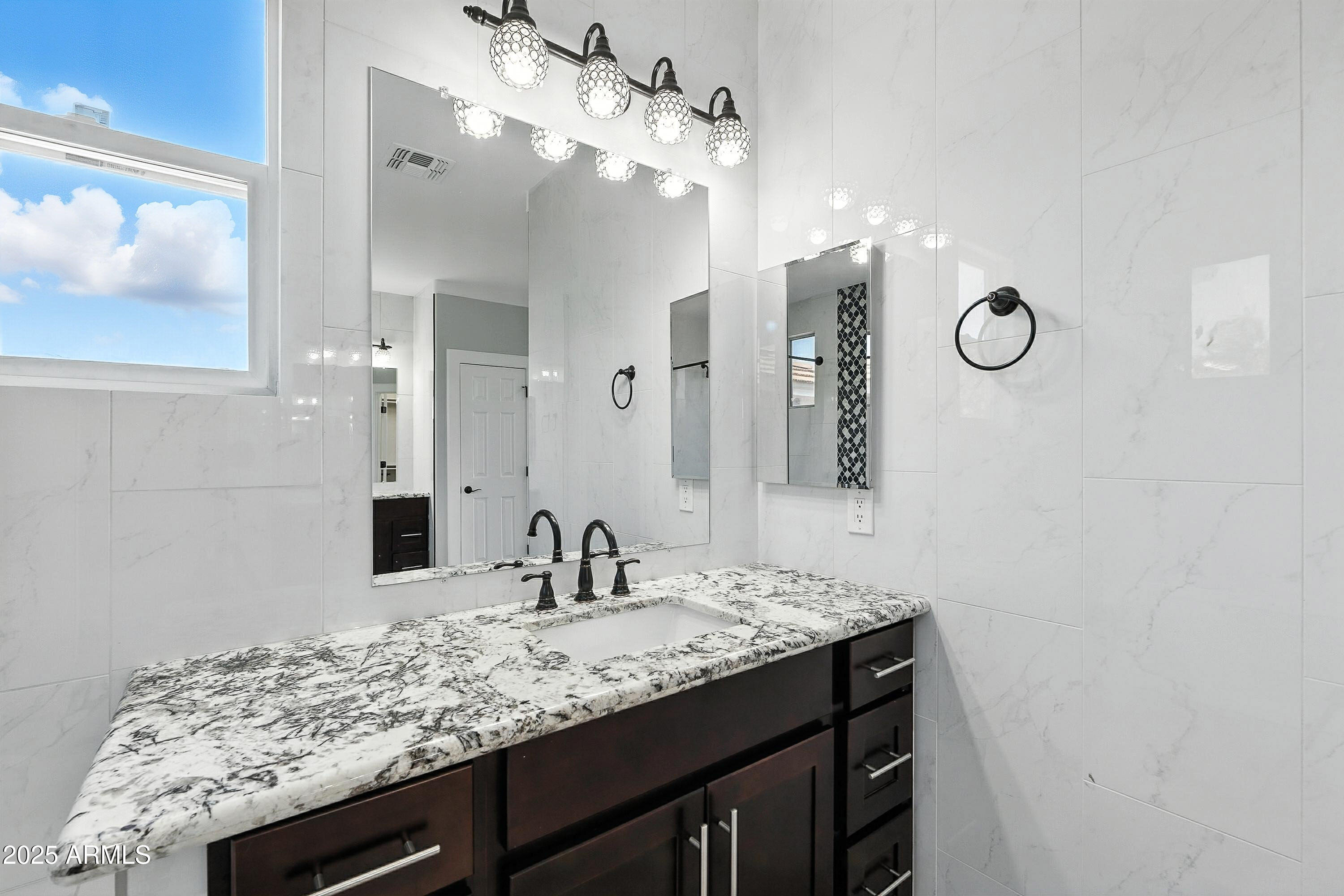 3042 South Seton Avenue Gilbert, AZ 85295 - Photo 39 of 71 a bathroom with a granite countertop sink a mirror and vanity