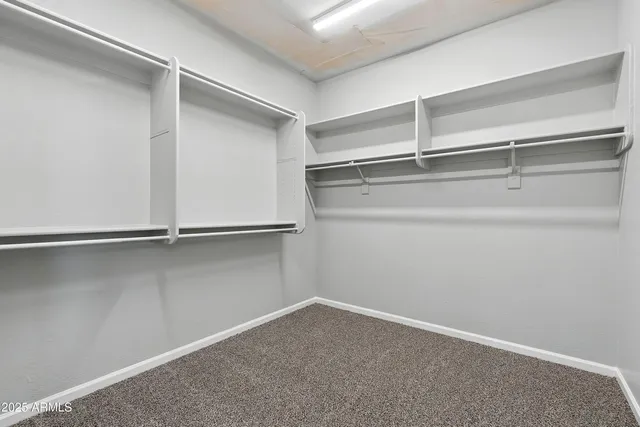a view of an empty room and chandelier fan