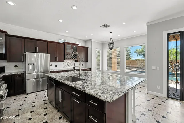 a kitchen with stainless steel appliances kitchen island granite countertop a sink and cabinets